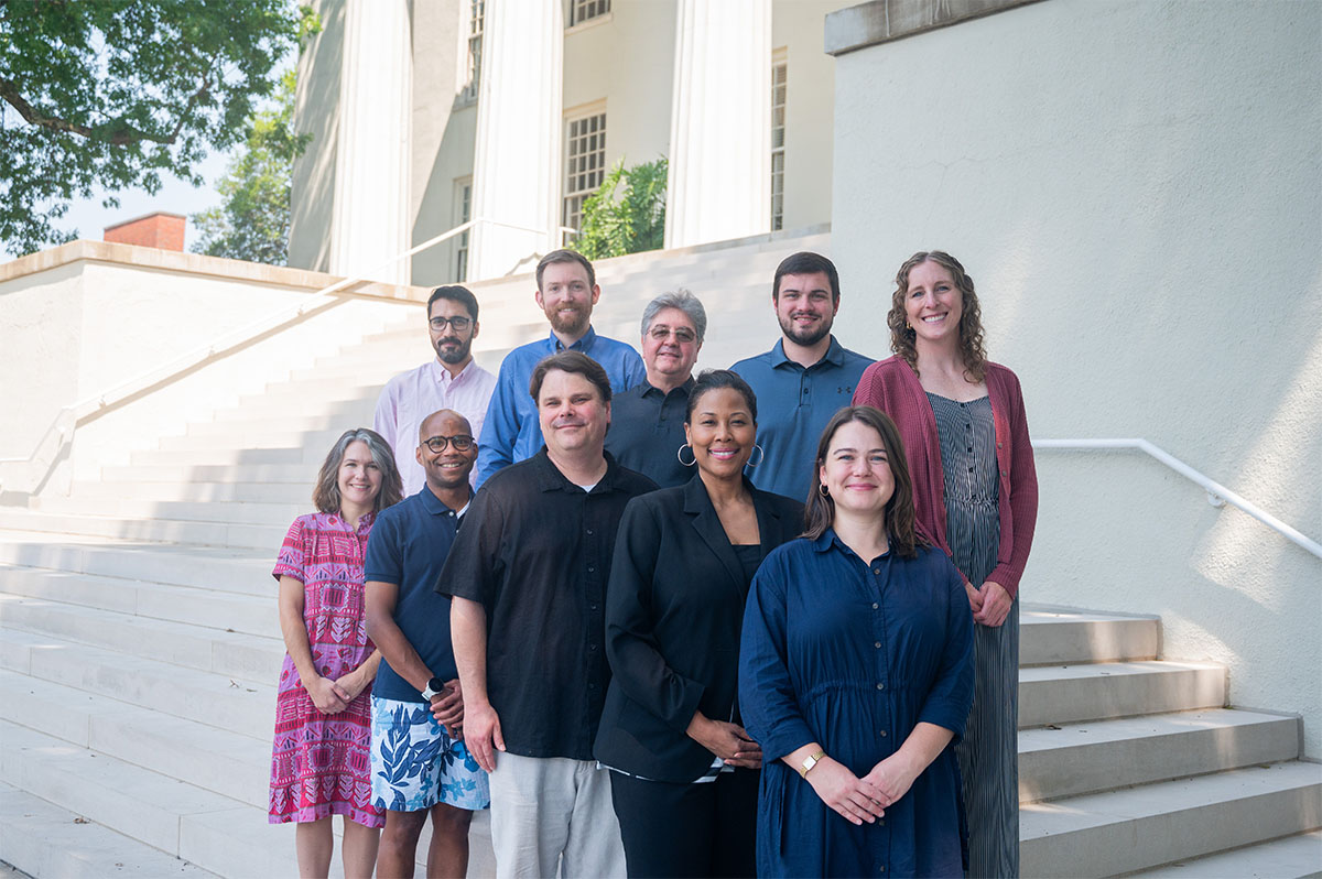 group posing in front of a campus building