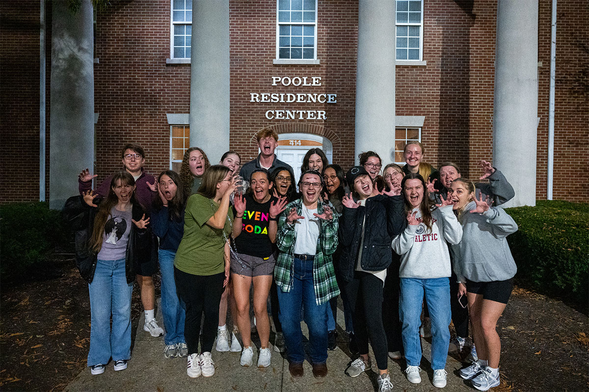 people posing in front of a haunted house