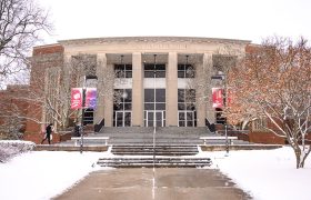 snowy scene in front of a campus building