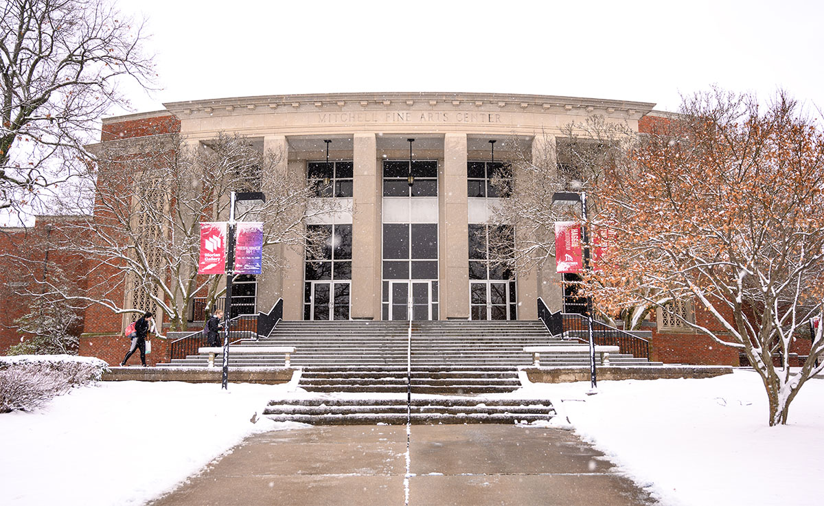 snowy scene in front of a campus building