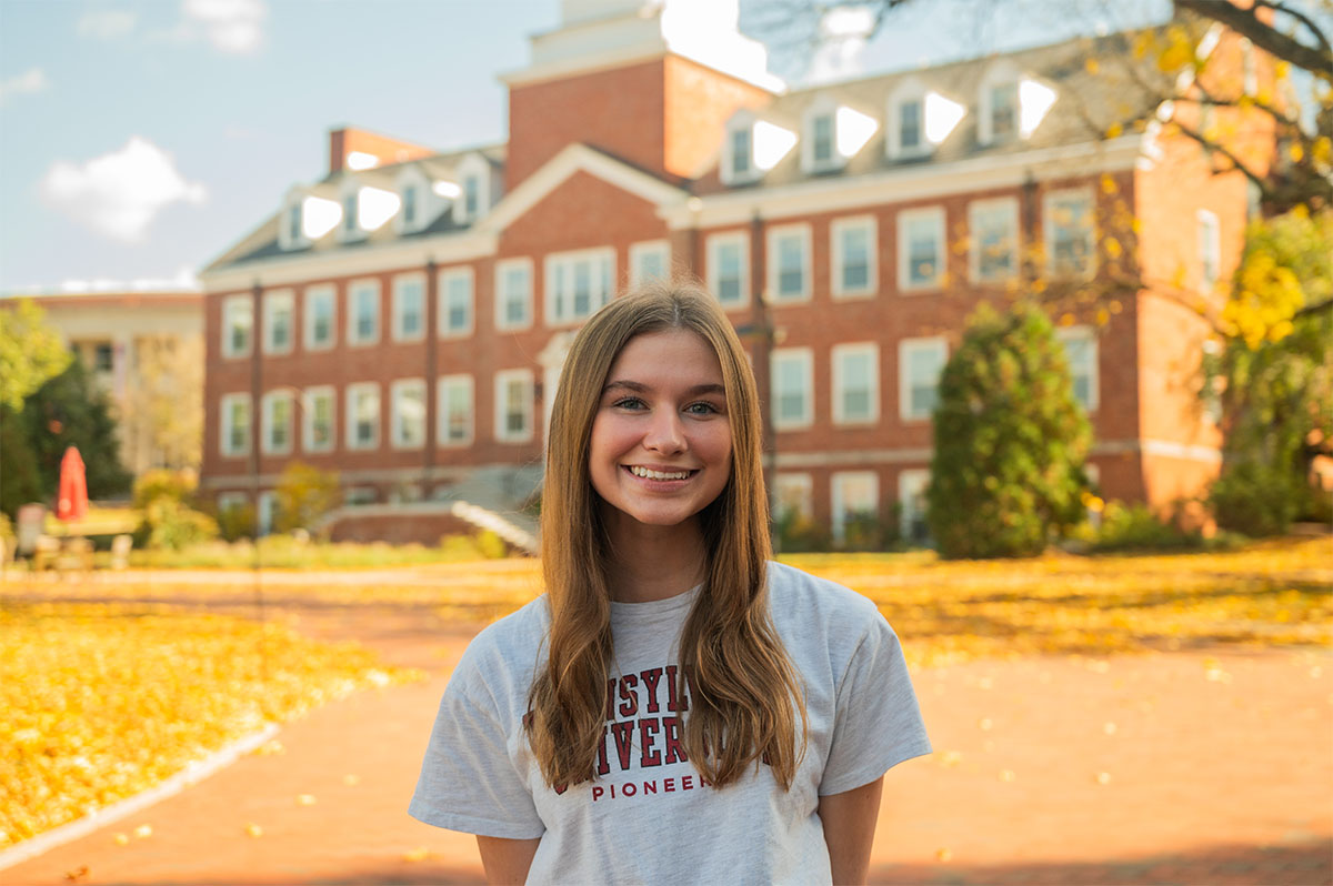 student in front of a campus building