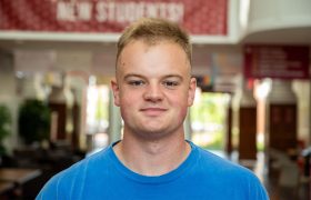 headshot of a student in a hallway