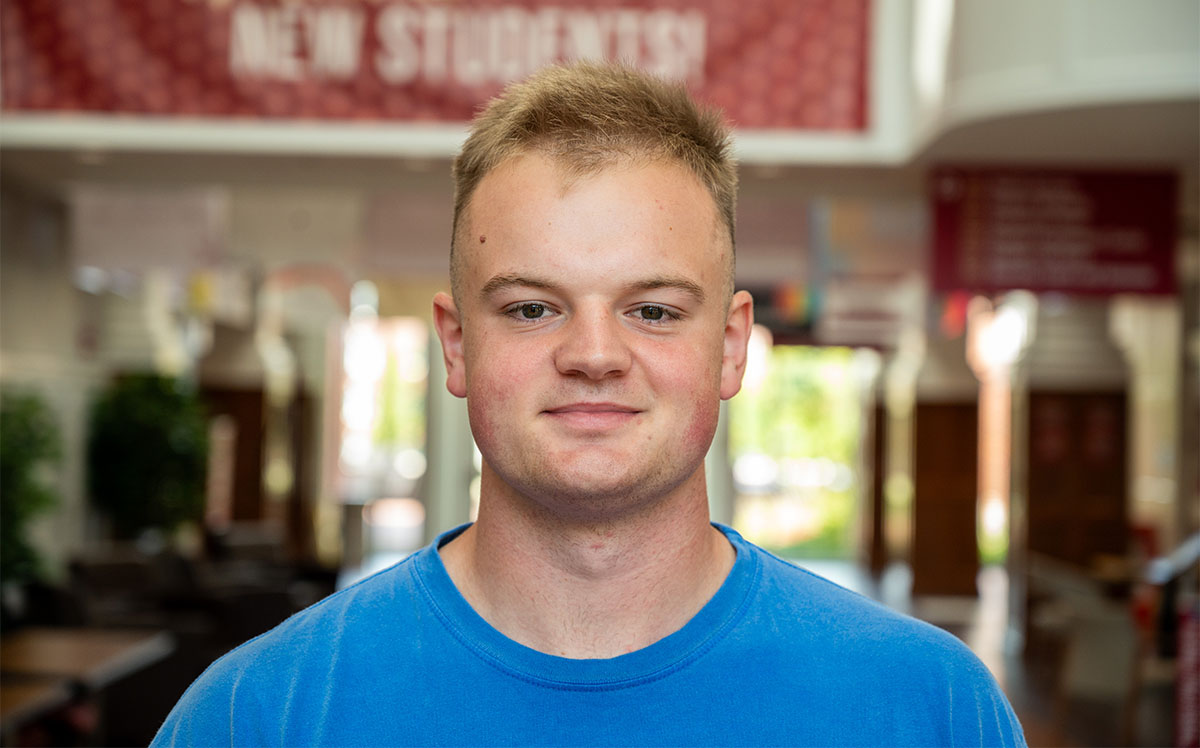 headshot of a student in a hallway