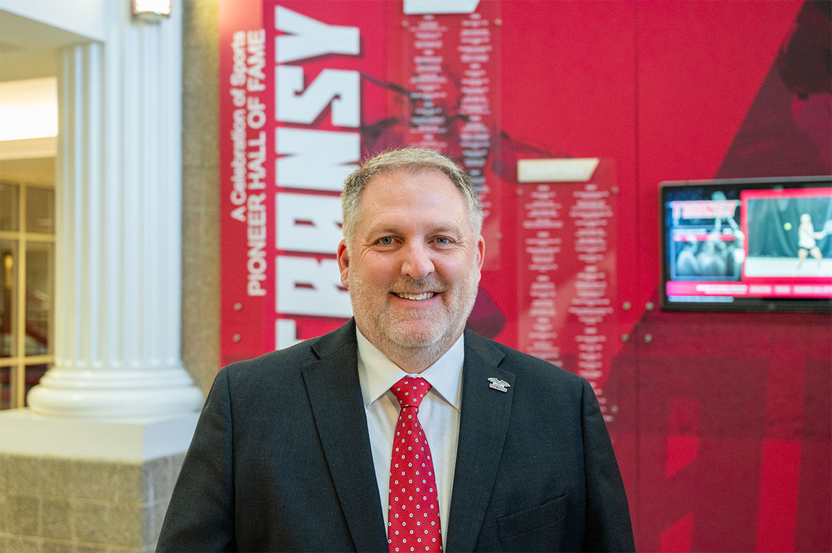 headshot of a man posing in an athletics center