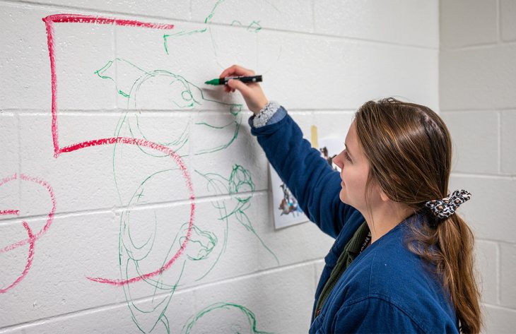 student painting a mural