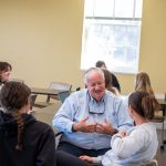 Older gentleman speaks with students in classroom