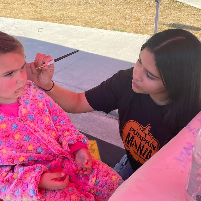 student painting a child's face