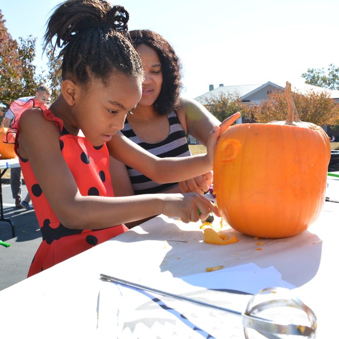 a child carving a pumpkin