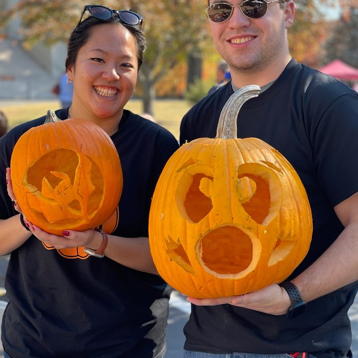 students showing off finished jack-o-lanterns