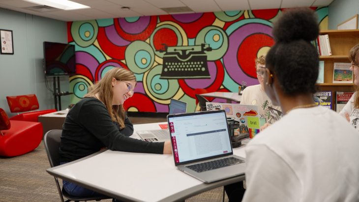 Savannah working with other students in the writing center