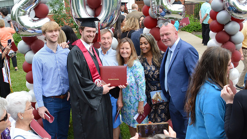 new graduate with family after commencement